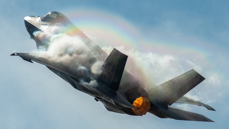 An F-35 flying as vapor moves across the aircraft