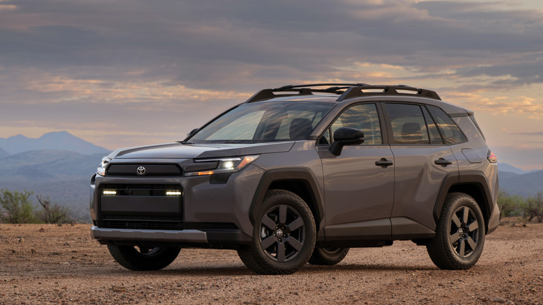 Front 3/4 view of gray Toyota RAV4 Woodland parked on desert trail.