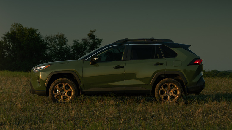 Side view of green Toyota RAV4 Woodland parked in field.