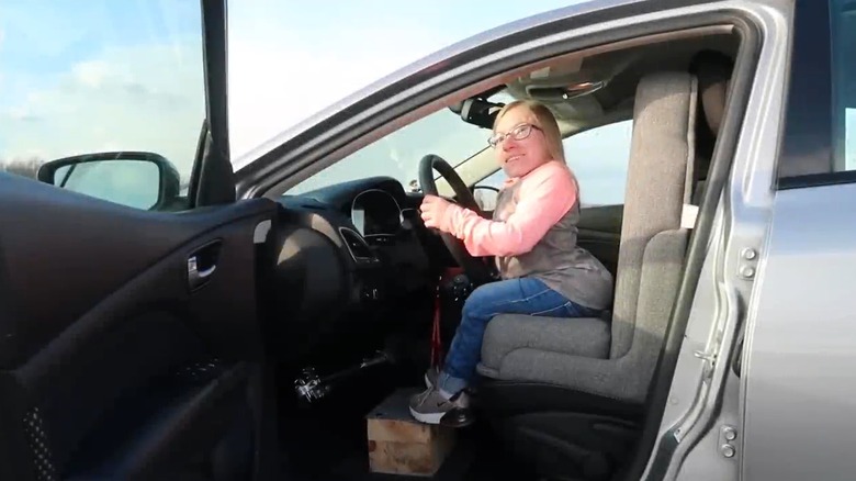 A little person behind the wheel of a car