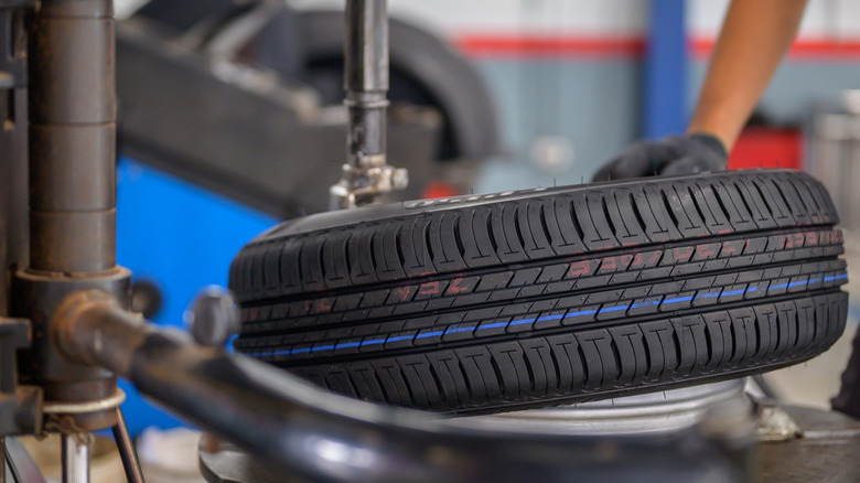 A new car tire being fitted