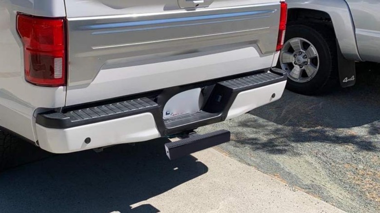 A gray pickup truck with an Eapele hitch step installed