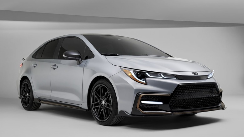 A facelift-generation silver Toyota Corolla from 2021 in the sedan bodystyle against a gray studio backdrop.