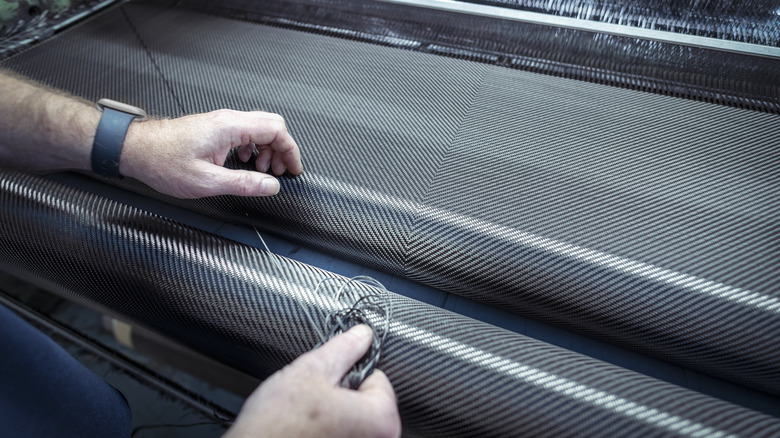 A person weaving carbon fiber