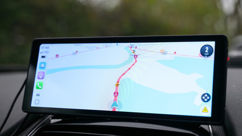 A car's central screen showcasing Apple CarPlay system with a Waze navigation app.