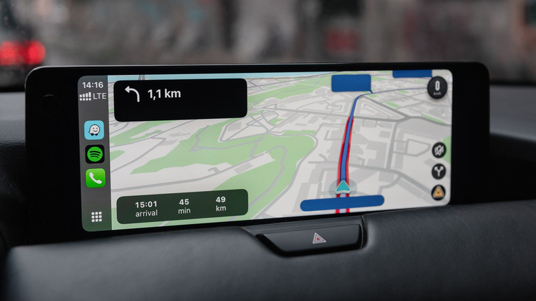 Apple CarPlay system using Waze navigation app on a car's central screen.