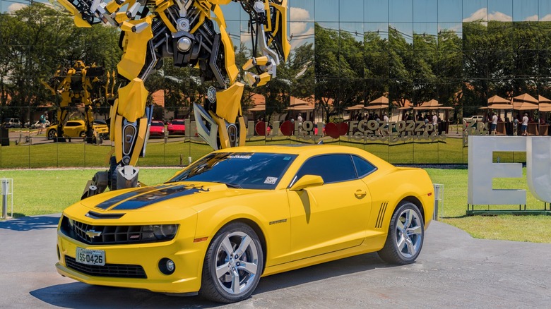 Yellow Camaro beside Bumblebee Transformer