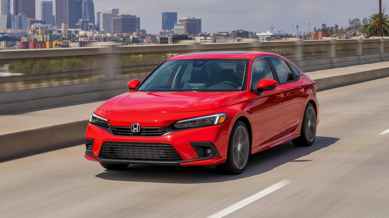 Front view of red 2022 Honda Civic sedan on city highway