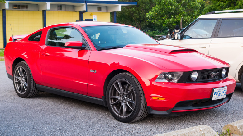 A red color Ford Mustang GT S197 II parked in a parking lot