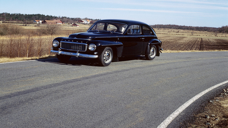 Black 1959 Volvo PV544 parked on a road