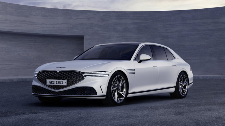 A silver Genesis G90 studio shot