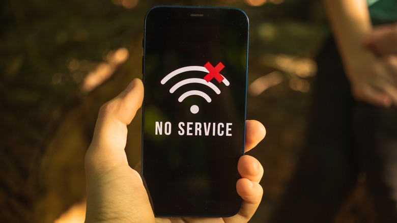 A person holding phone showing no service error