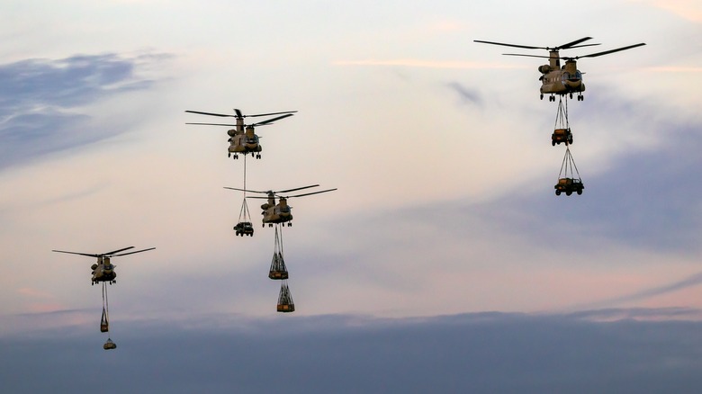 Four Chinook transport helicopters carrying cargo