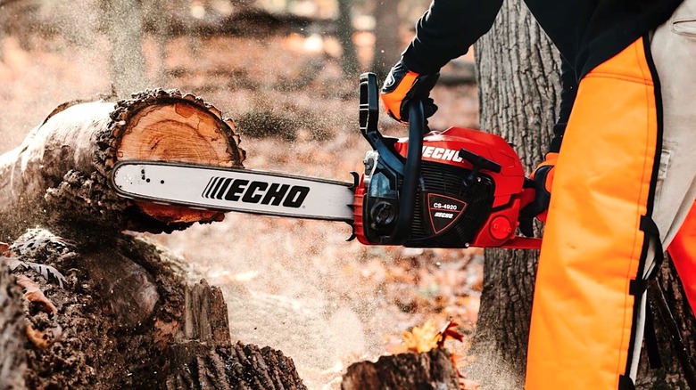Person cutting wood with an Echo chainsaw