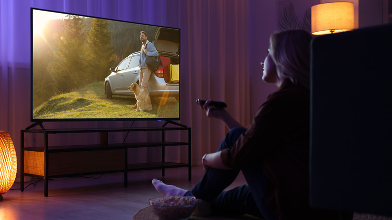 Person using remote to adjust TV