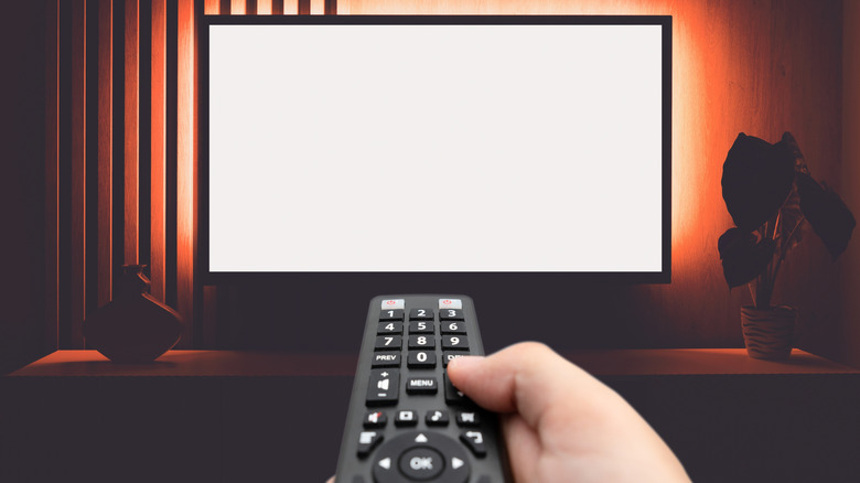 Person using remote to adjust television