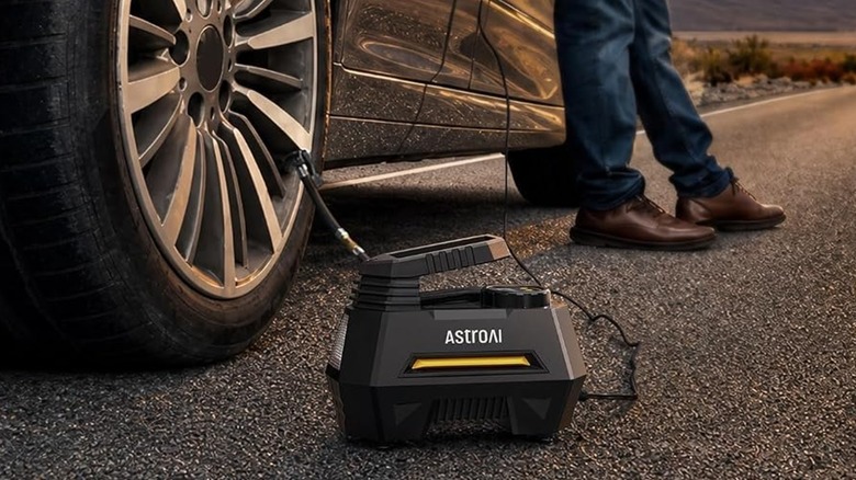 An AstroAI AIRUN H Portable Inflator and Pressure Gauge being used to reinflate a car tire.