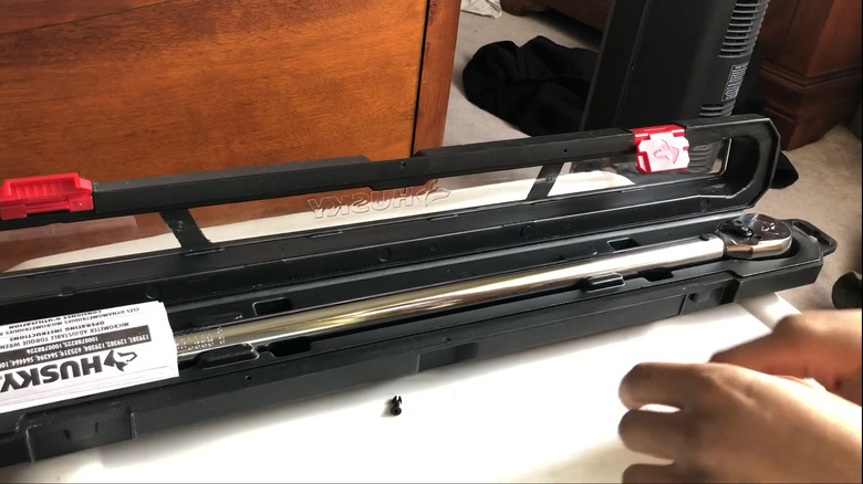 A person opening the Husky 1/2 in. Drive Torque Wrench's case