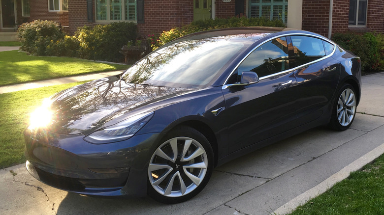 tesla model 3 blue parked driveway