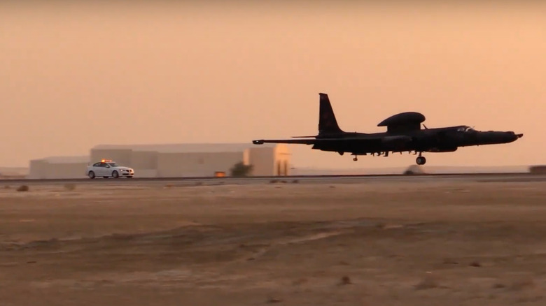 A U-2 Dragon Fly plane being chased by a chase car during landing