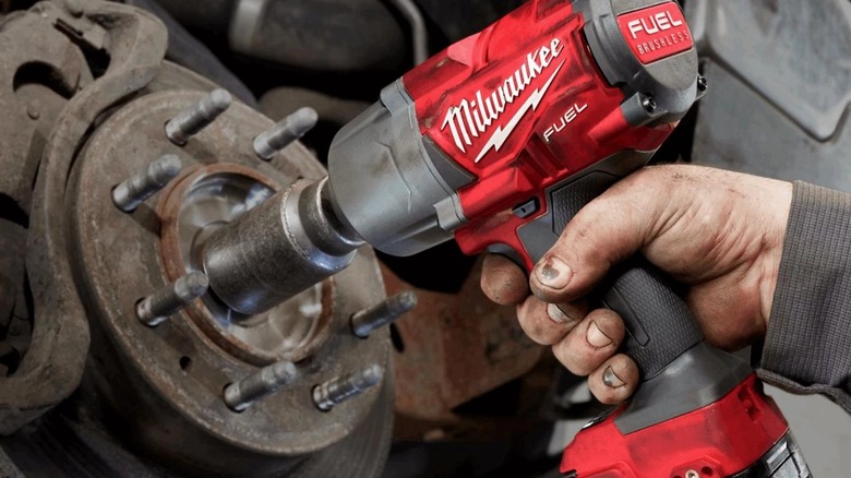 Person using Milwaukee torque wrench on wheel
