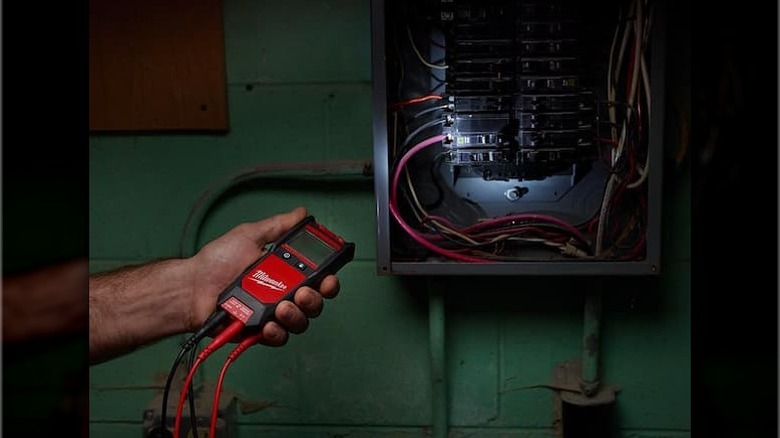 Person using Milwaukee Auto Voltage/Continuity Tester on breaker box