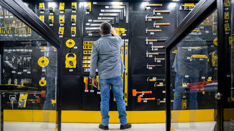 man looking at tools in a hardware store