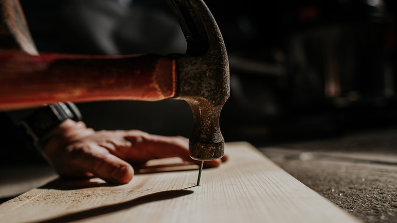 hammering a nail into a board