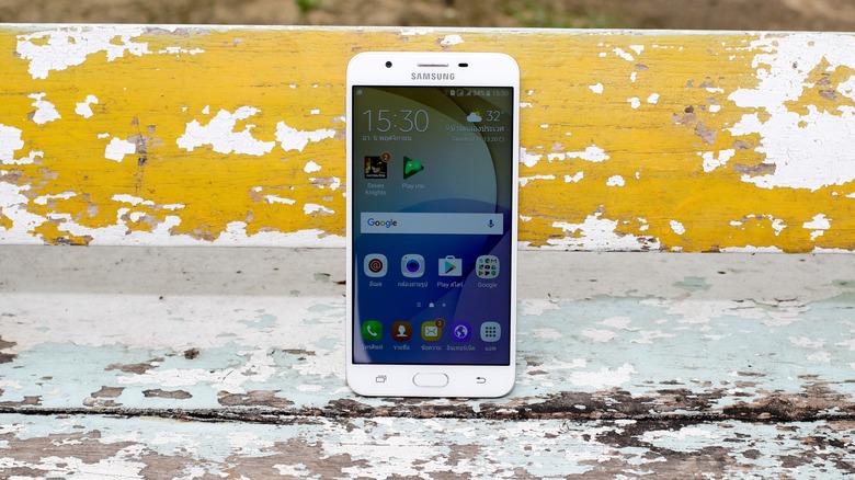 A smartphone on the ground with paint around.