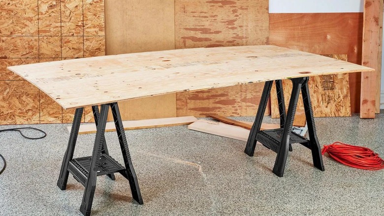 Central Machinery 32-inch, 500-lb Capacity Polypropylene Folding Sawhorse holding up wood