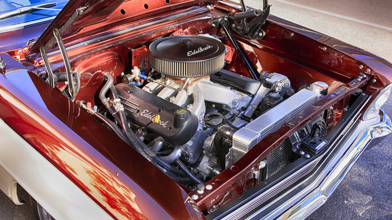 A Chevrolet 327 engine with aftermarket parts in a red engine bay