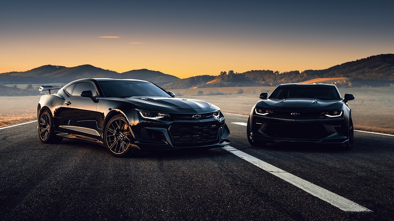 two Chevy Camaros parked road