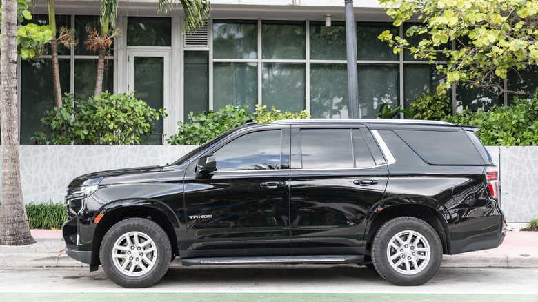 Side view of black Chevy Tahoe parked on street.
