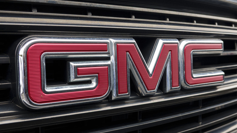 Close-up of a red GMC logo on a silver grille