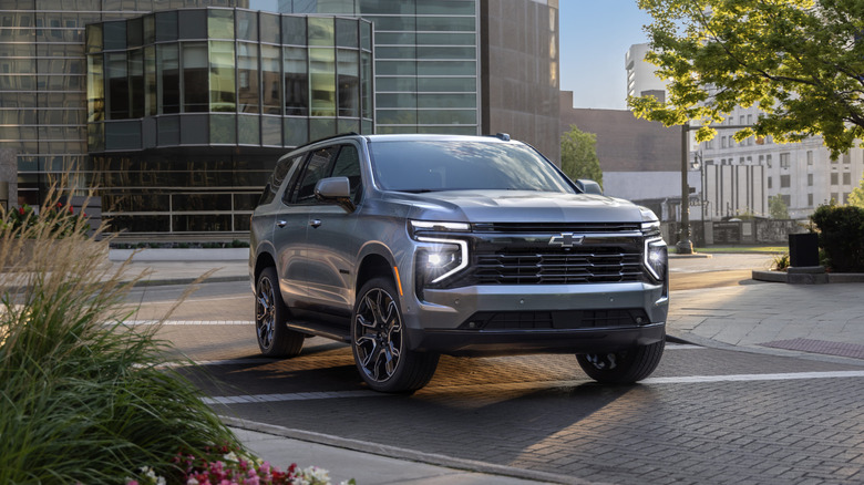 A silver 2026 Chevrolet Tahoe sitting in front of a modern city building