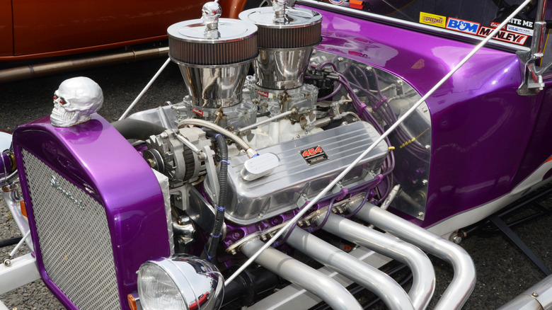 A purple hot rod with a Chevy 454 big block engine, featuring skulls on the dual air cleaners