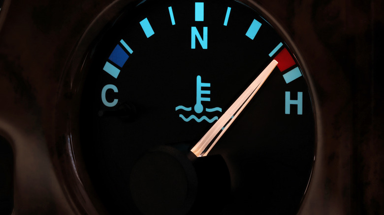 A vehicle's coolant temp gauge in night mode, with the dial pointer all the way to hot