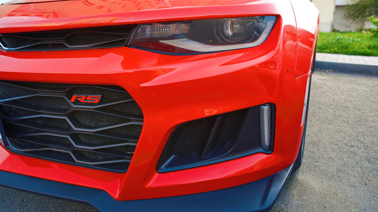 Red RS badge displayed on the front grille of a Chevy Camaro