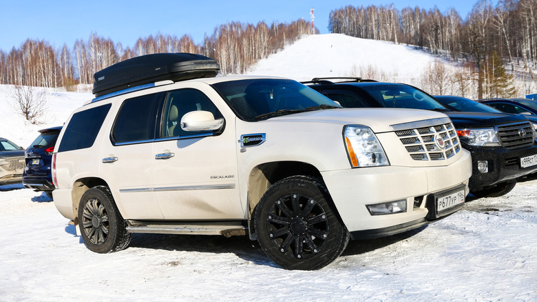 A white Cadillac Escalade in snow-covered lot