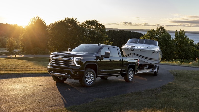 Black Chevy HD pickup towing boat on park roadway