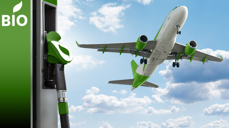 Airliner painted in green and white taking off with a biofuel pump is prominent in the foreground