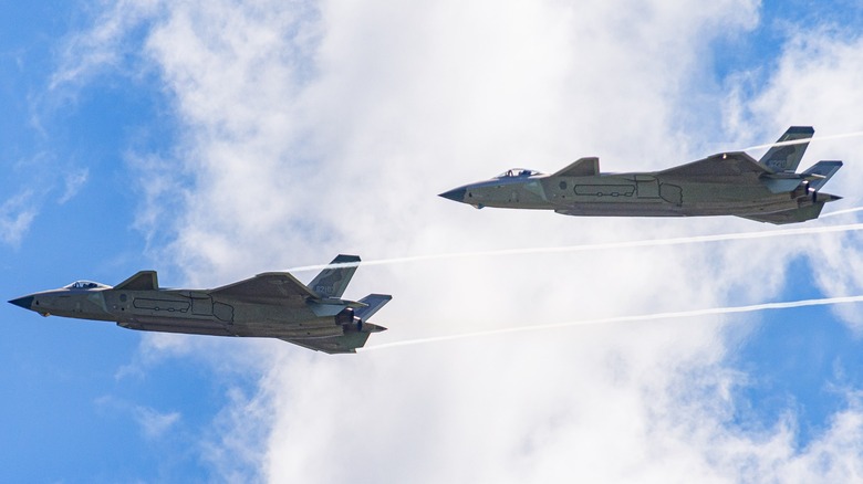 Two Chinese J-20 fighter jets flying at an air show in 2022
