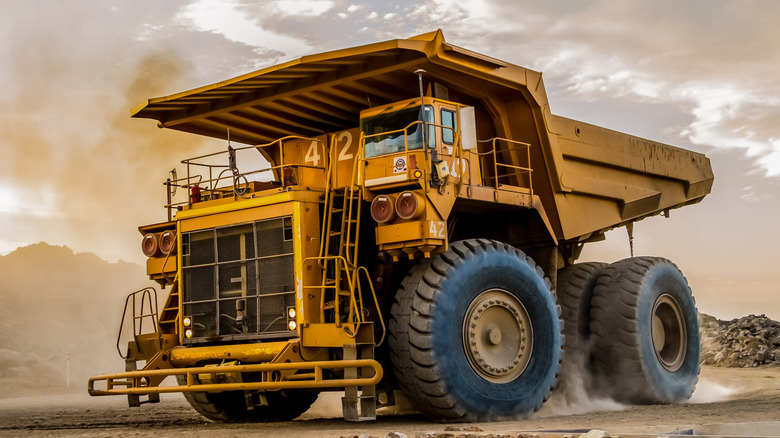Front 3/4 view of mining dump truck in mine setting