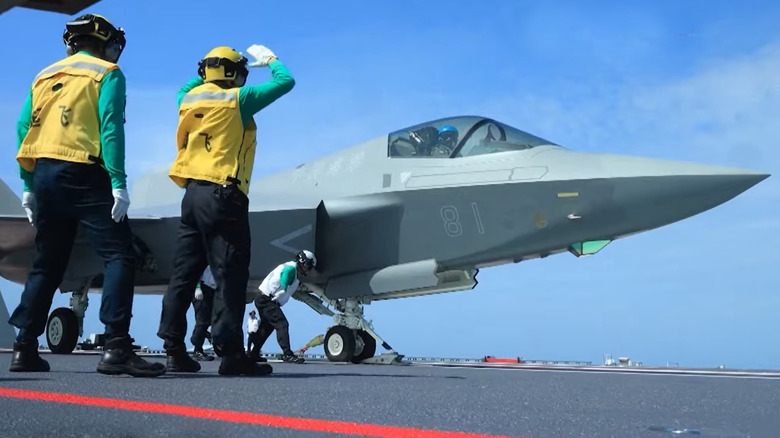 Flight crew on the Fujian working on a jet fighter on the ship's deck