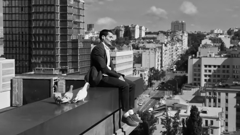 Man sitting on roof in airpods commercial