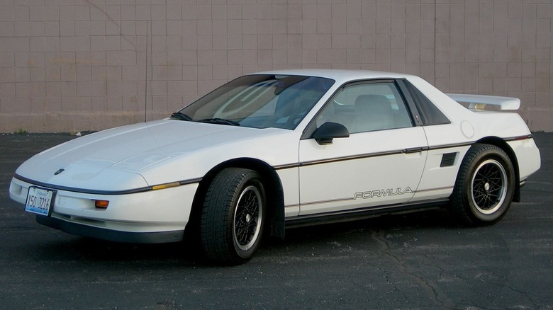 white Pontiac Fiero parked on pavement