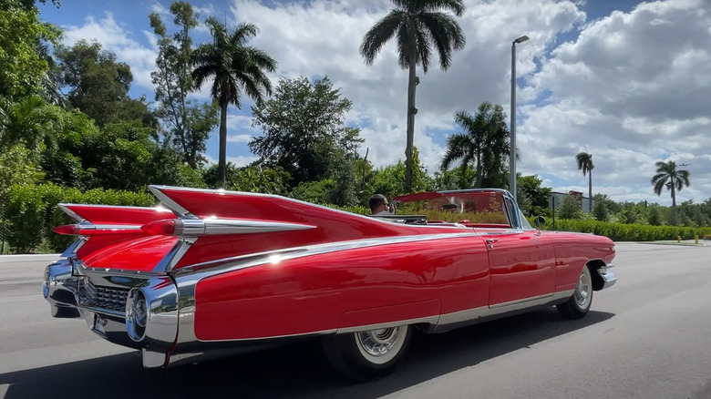 Side view of a 1959 Cadillac Eldorado convertible in metallic green, showcasing its iconic tailfins and dual bullet taillights