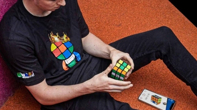 Man sitting on floor holding a rubik's cube