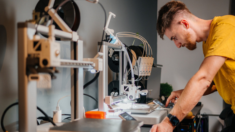 Designer hunches over 3D printing project