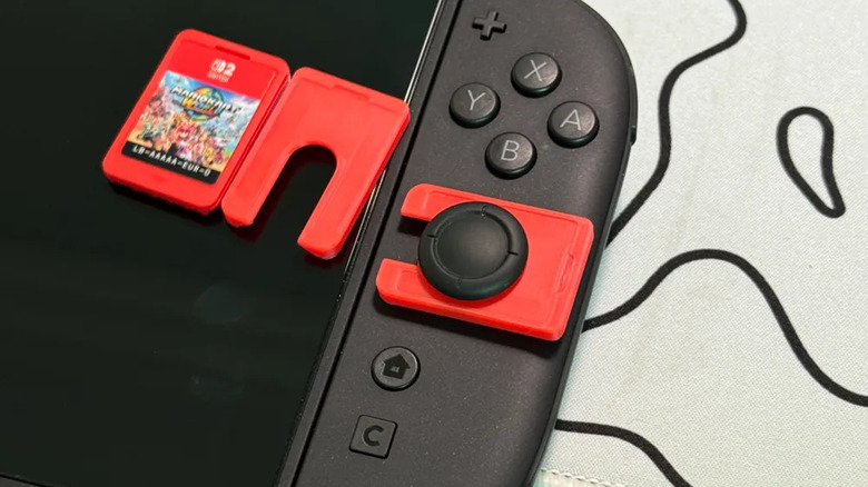 Stick lock protector installed on a Nintendo Switch next to another stick lock and a Switch cartridge game
